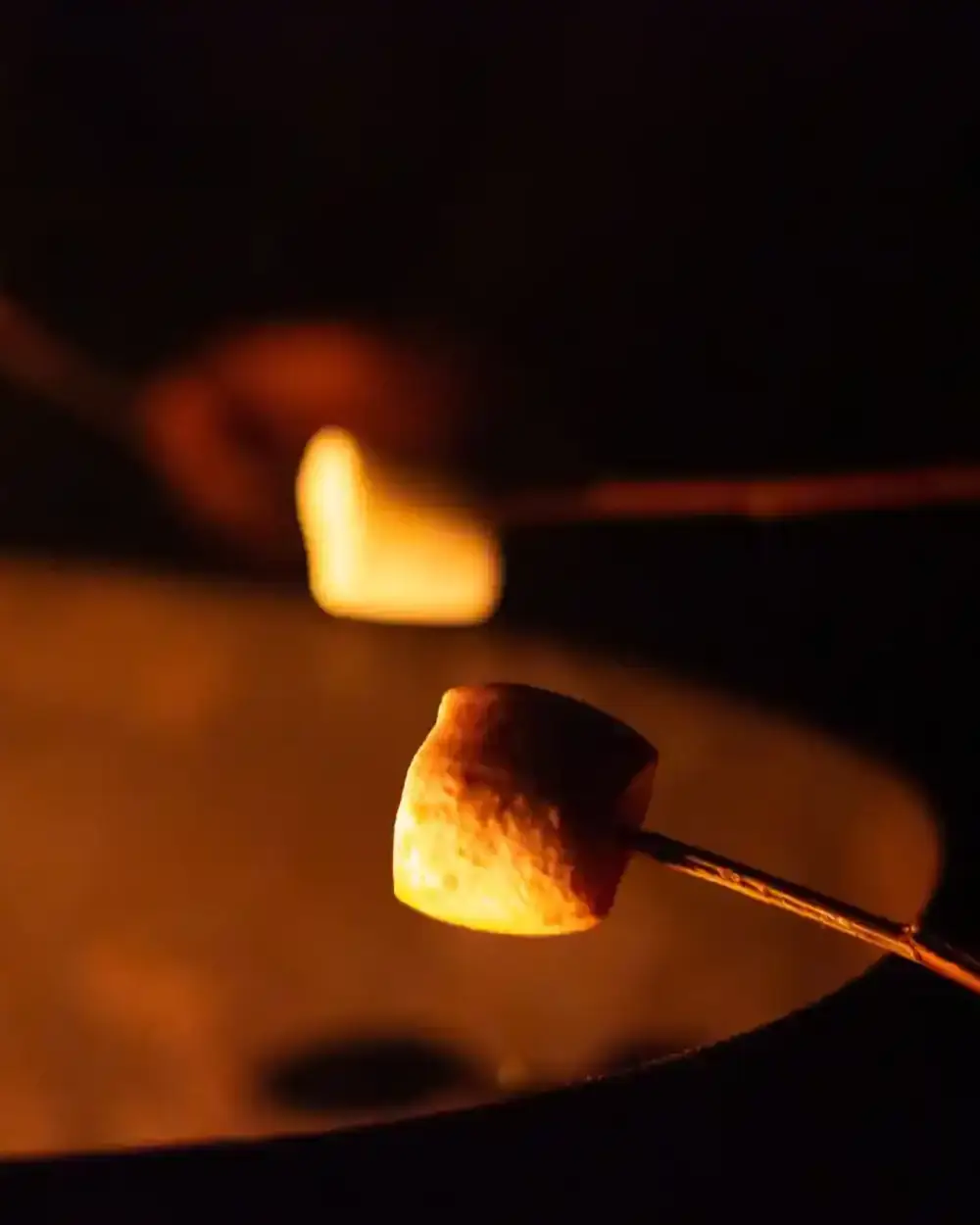 Kamp ateşinin üzerinde kızaran marshmallow